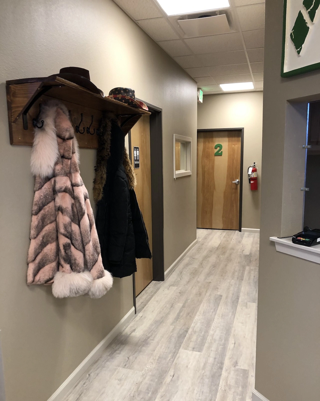Mountain Medical Practice office interior hallway with winter parka and fur apparel hanging on western style coat hook wall mount