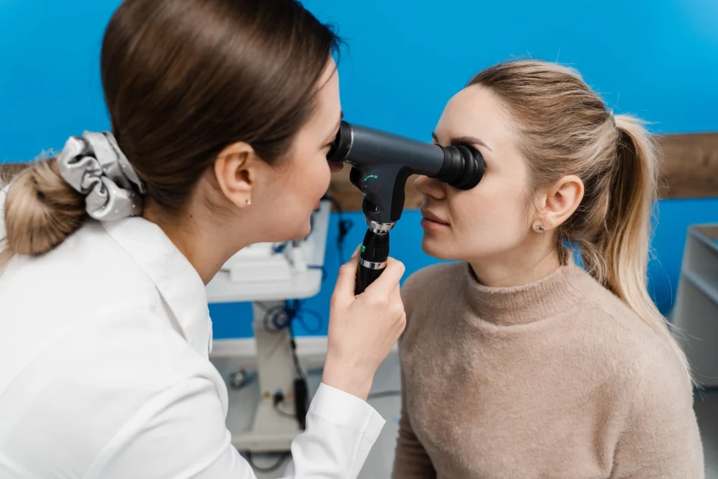 Female physician using the Panoptic ophthalmoscope to examine a young female patient’s eyes