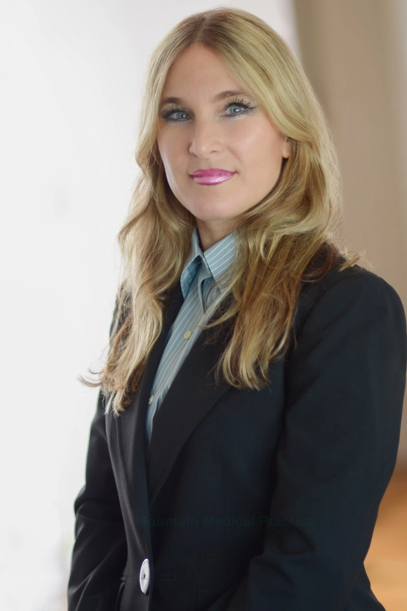 Dr. Maria Pirraglia in sky blue shirt with white pinstripes and black business suit