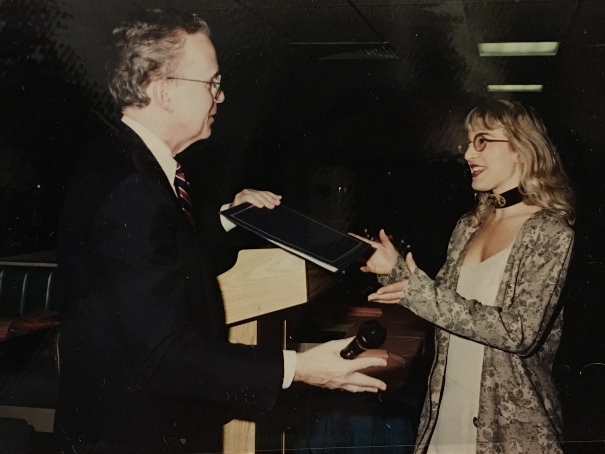 Dr. Maria Pirraglia in tan dress receiving professional diploma vintage photo