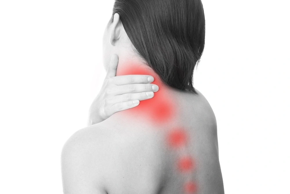 Female clutching upper neck muscles with trajectory of myofascial pain indicated in red