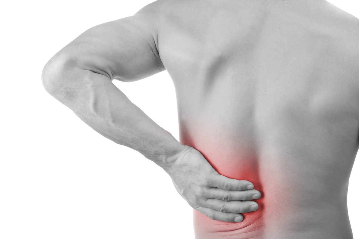 Male clutching low back muscles in pain