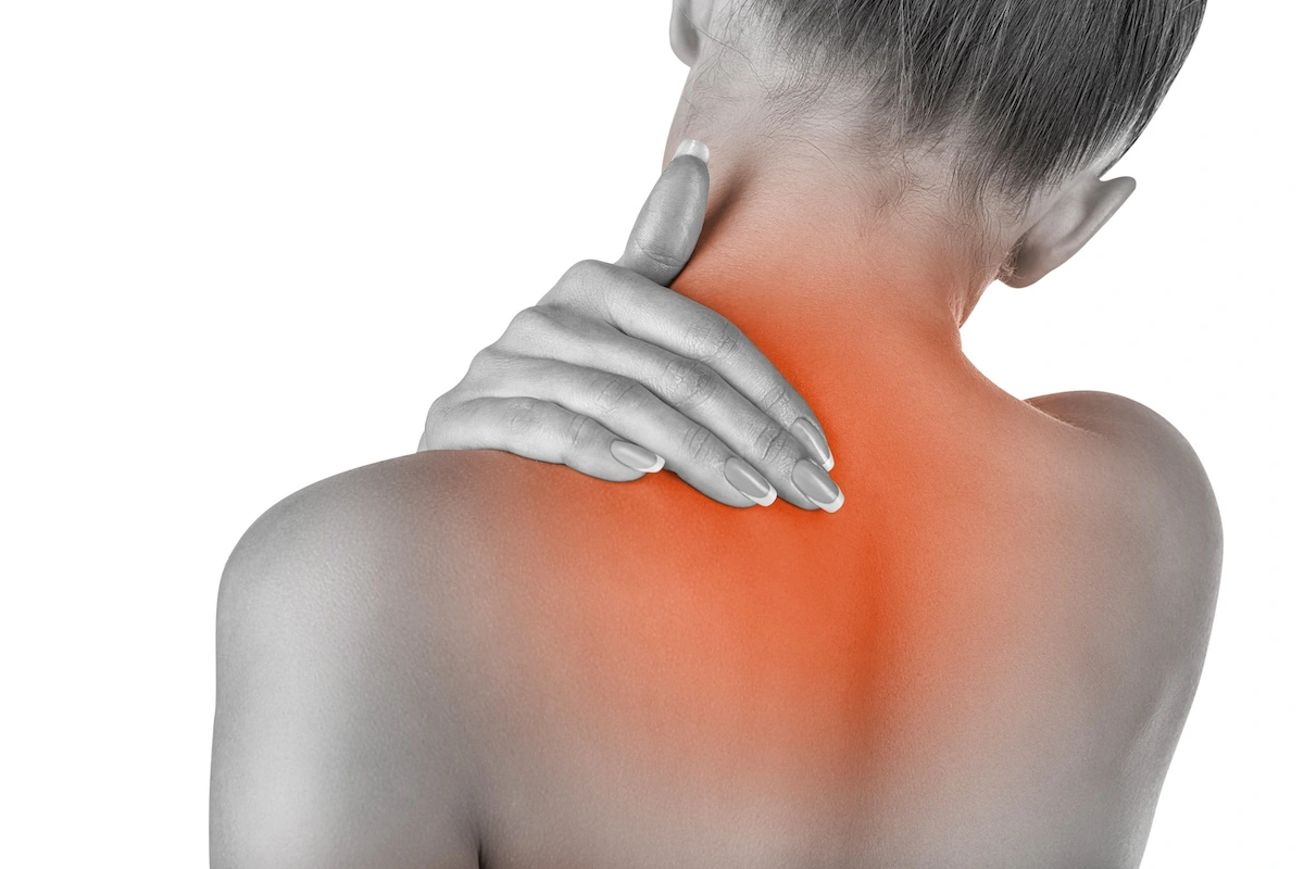 Female clutching neck and upper trapezius muscle in pain