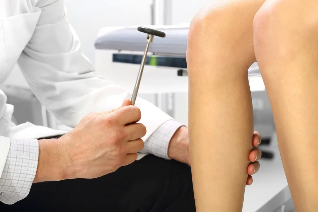 Male healthcare provider performing knee jerk reflex test