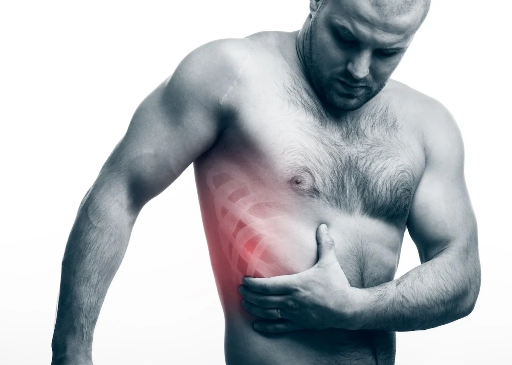 Male clutching torso in pain with inset hologram of ribs